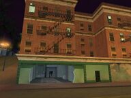 The damaged exterior of Big Smoke's Crack Palace following the mission End of the Line.