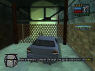 Toni Cipriani using a car to break down a chain-link fence to the escape tunnel at the second station.