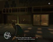 Niko Bellic throwing a brick through the shop window.