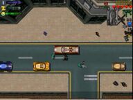 Claude Speed stealing a Medicar whilst the paramedics, in green, attend to a deceased man