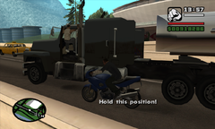 CJ prepares to board the rig as Cesar Vialpando jumps on board and incapacitates the driver.