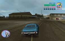 Tommy Vercetti driving towards the landing spot for the courier in Viceport.