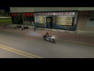 A biker riding away on Mitch Baker's motorcycle.