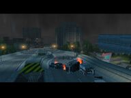 The destroyed police convoy with Claude and 8-Ball in the distance.