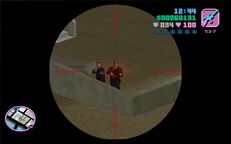 Tommy Vercetti about to shoot a man in black attire in the compound behind the Cherry Popper Ice Cream Factory.