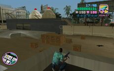 Tommy Vercetti, with his gun ready, looking at the Cherry Popper Ice Cream Factory.