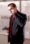 Alternate concept artwork of Mikhail Faustinin GTA IV, being mirrored and welding a gun in place of a wad of cash.