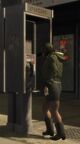 A pedestrian using a public telephone in GTA IV.