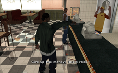 Ryder attempting to rob the pizza parlor as Carl looks on.