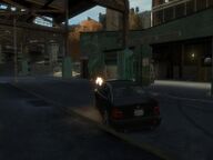 Niko Bellic performing a drive-by shooting.