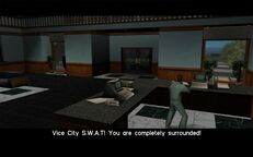 Tommy Vercetti aiming his gun at the door for the SWAT attack.