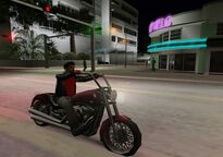 A biker parking his motorcycle opposite Rafaels.