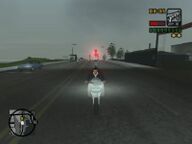 Toni Cipriani driving towards the ambush while being pursued by Forelli Family mobsters.