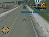 Claude driving a remote controlled vehicle, strapped with explosives, towards a Purple Nines vehicle.