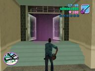 Tommy Vercetti, armed with a chainsaw, about to enter Gonzalez' apartment building.