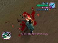Tommy Vercetti attacking the corpse of Gonzalez with a chainsaw.
