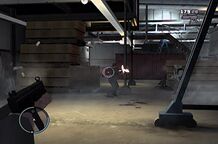 Niko Bellic shooting at the employees inside the warehouse.